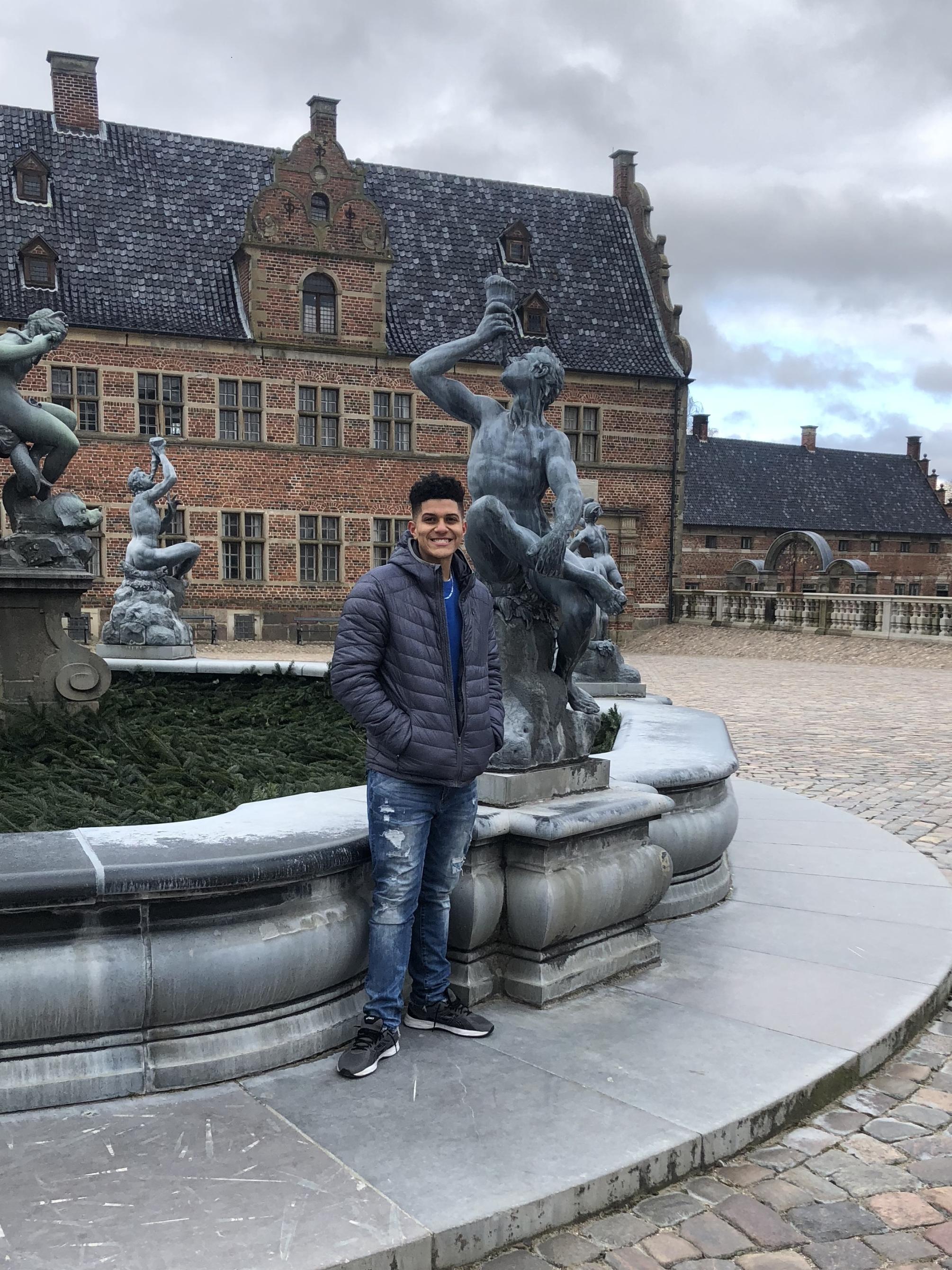 Jermain Jones stands in courtyard at castle in Denmark during study abroad trip over spring break