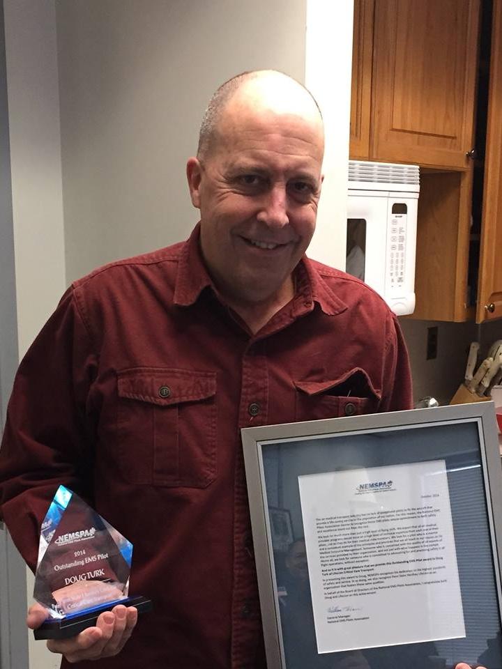 Doug Turk holds the award he received from the National EMS Pilots Association.