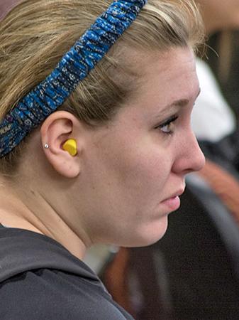 Student wears earplug for class experiment