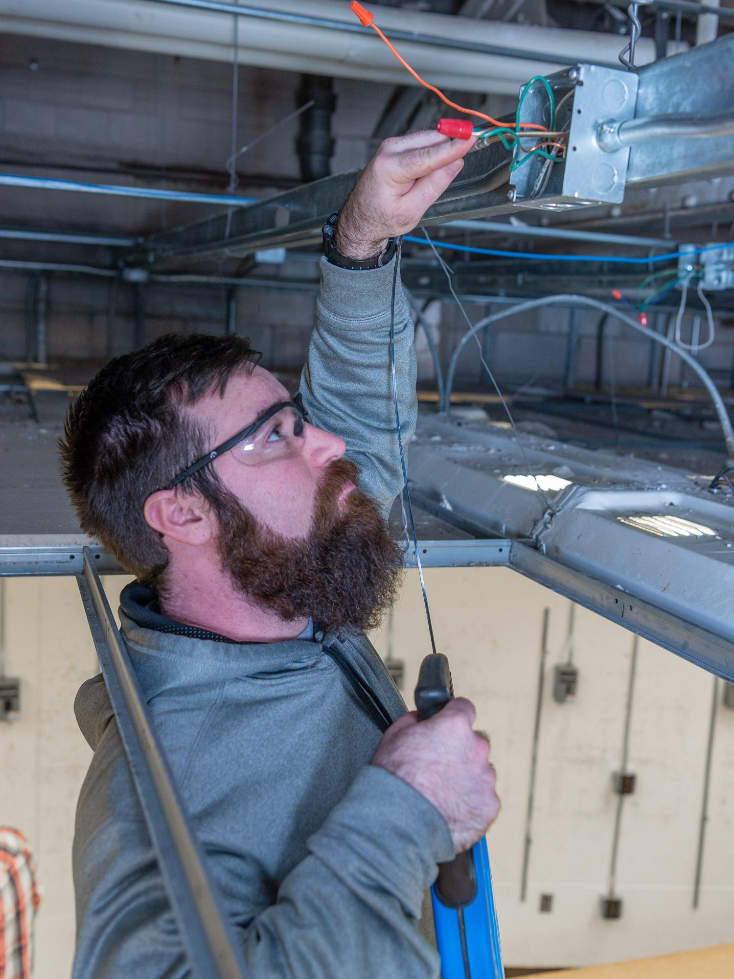 An electrician works on wiring for construction