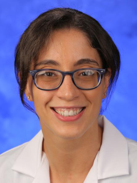 Dr. Nora Elfiky poses for a professional headshot, wearing a physician coat.