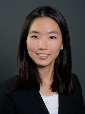 professor in business attire smiles and poses for professional headshot photo