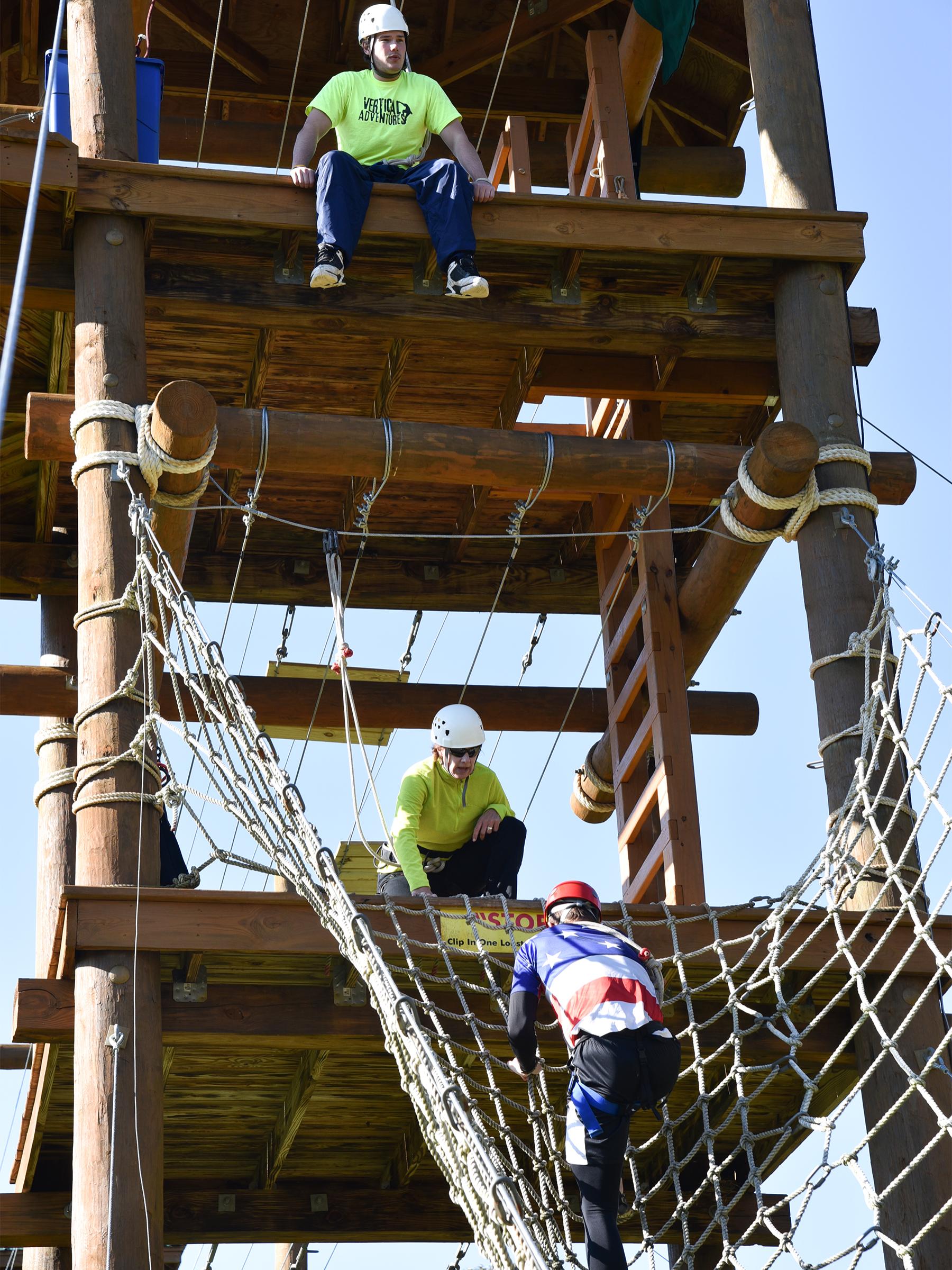 An Extreme Stater team helps each other complete the cargo climb obstacle 