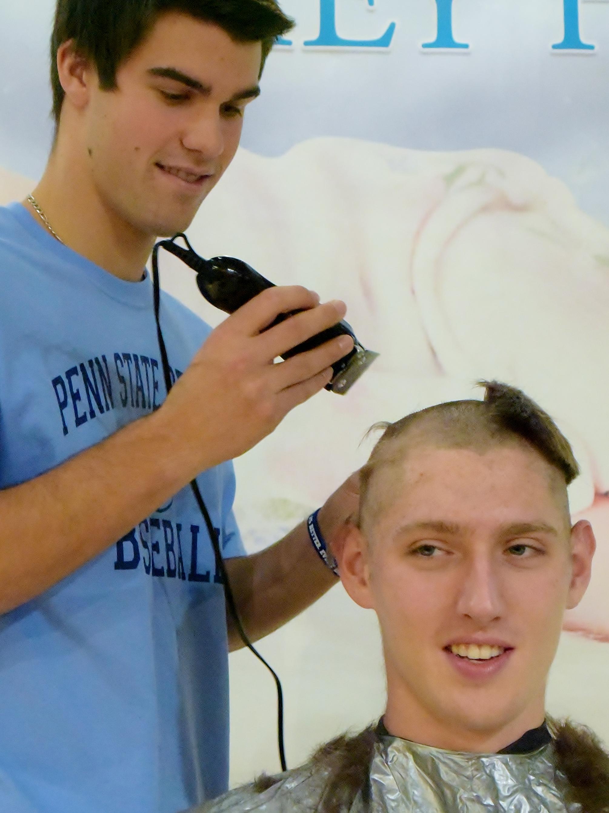 A Penn State Behrend student has his head shaved during a charity event.