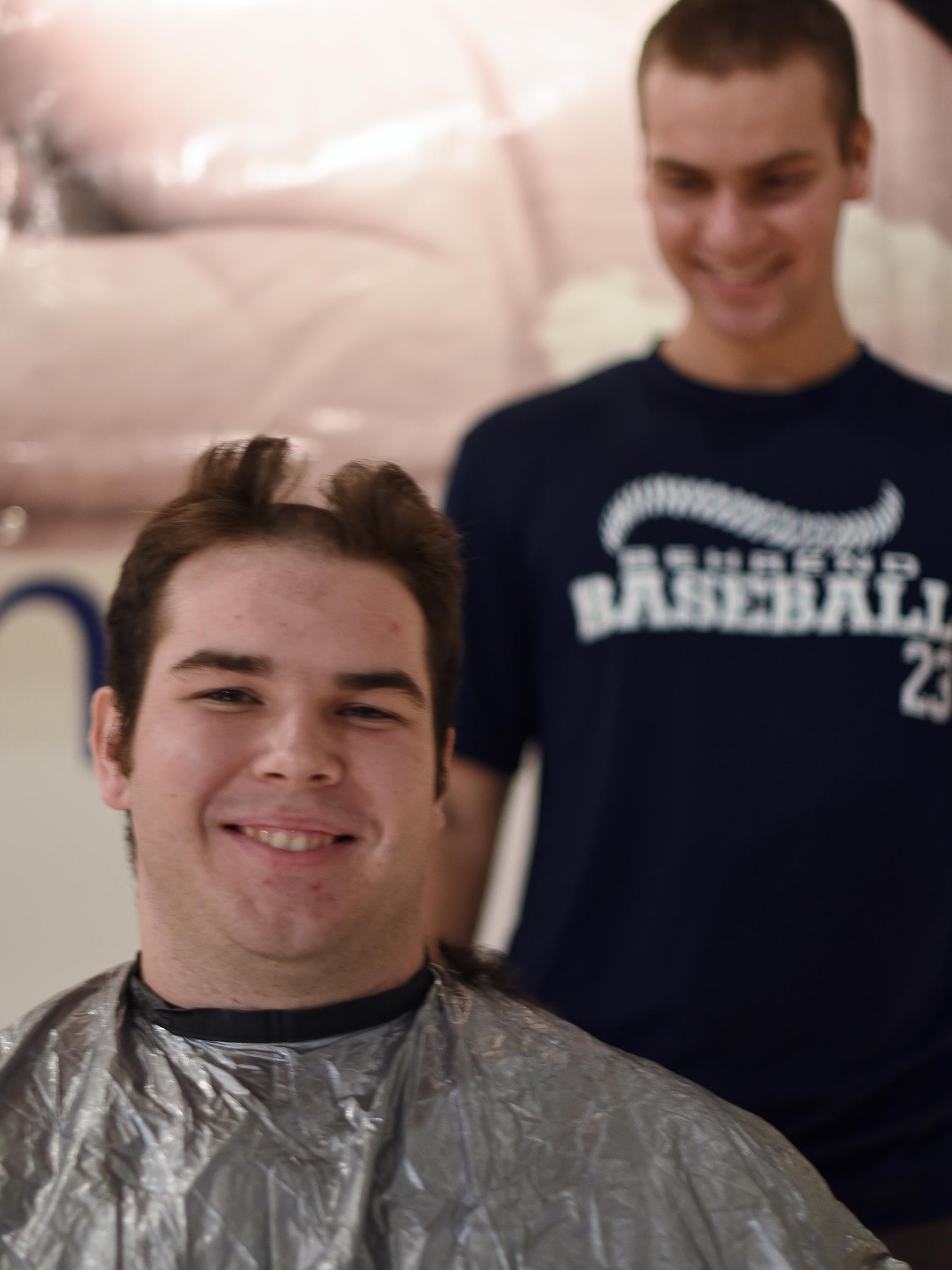 A Penn State Behrend baseball player has his hair cut for charity.