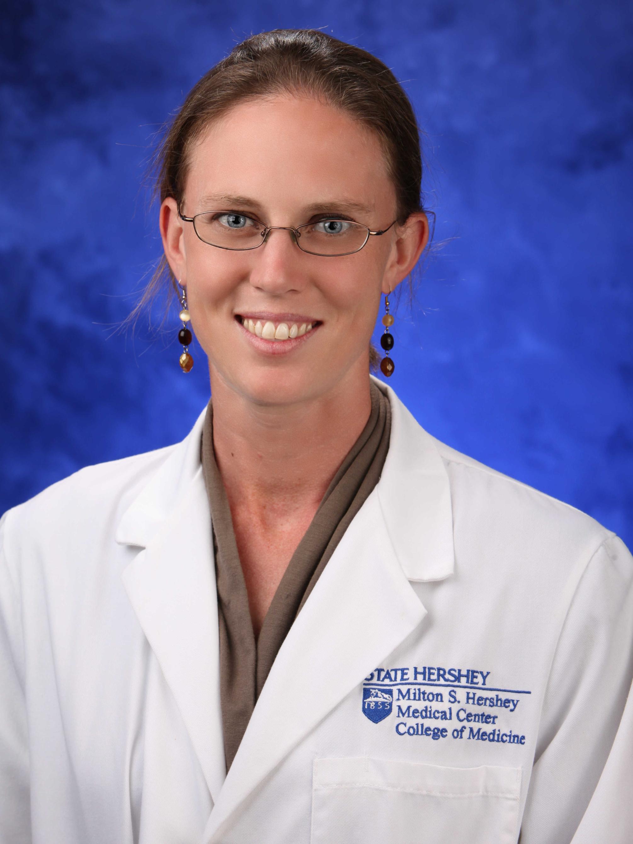 Dr. Jennifer Grana poses for a professional headshot wearing her medical coat.