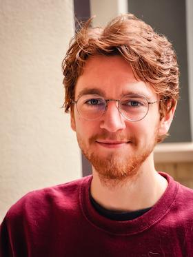A photo of a professor wearing glasses.