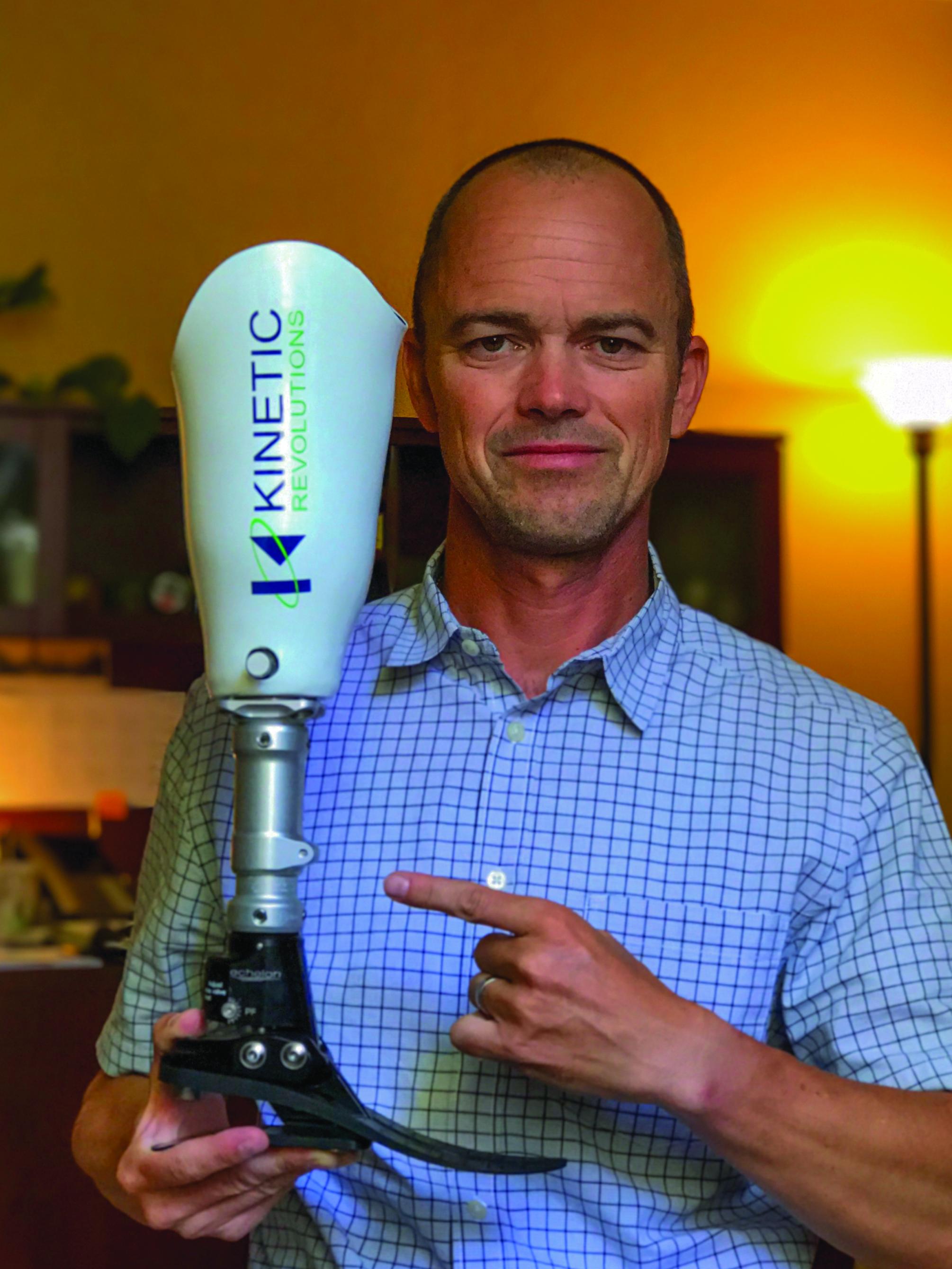 Mac Heebner holding prosthetic limb device