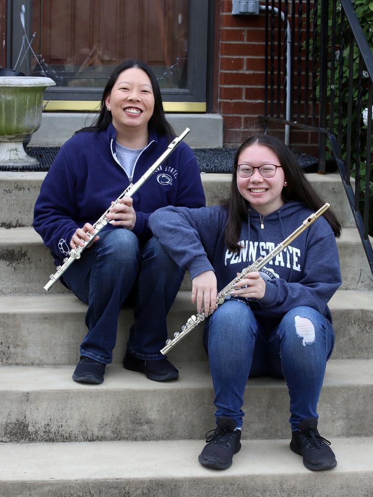 Faith Konidaris and her daughter sit on steps with their flutes