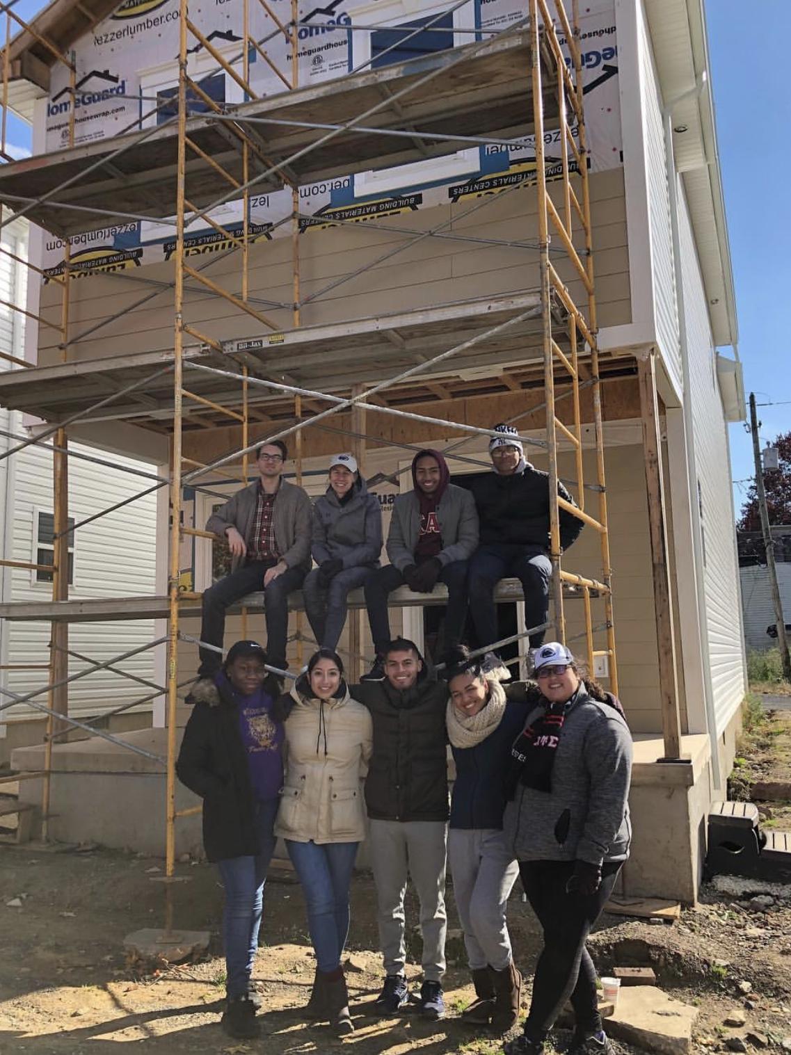 people in front of a home being built
