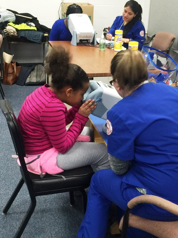 Nurses perform vision screenings on students.