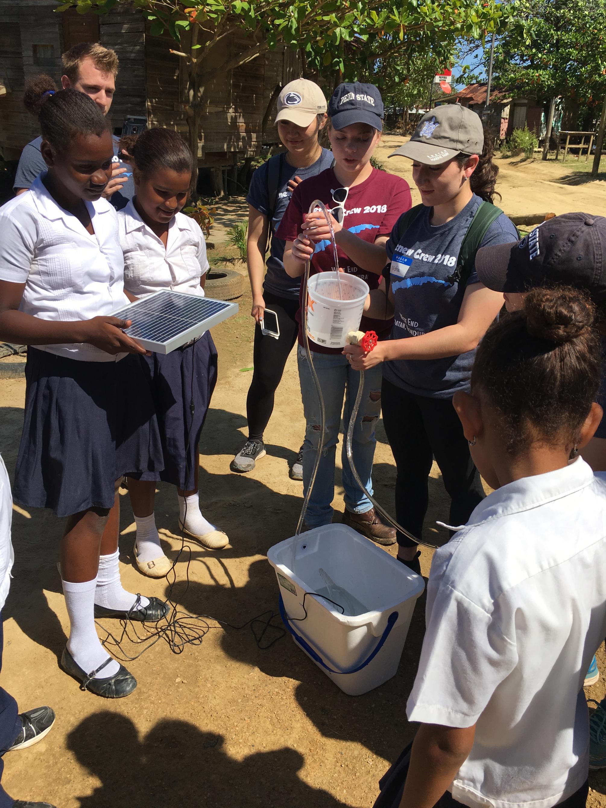 Students in Roatan with miniature solar water pumping system 