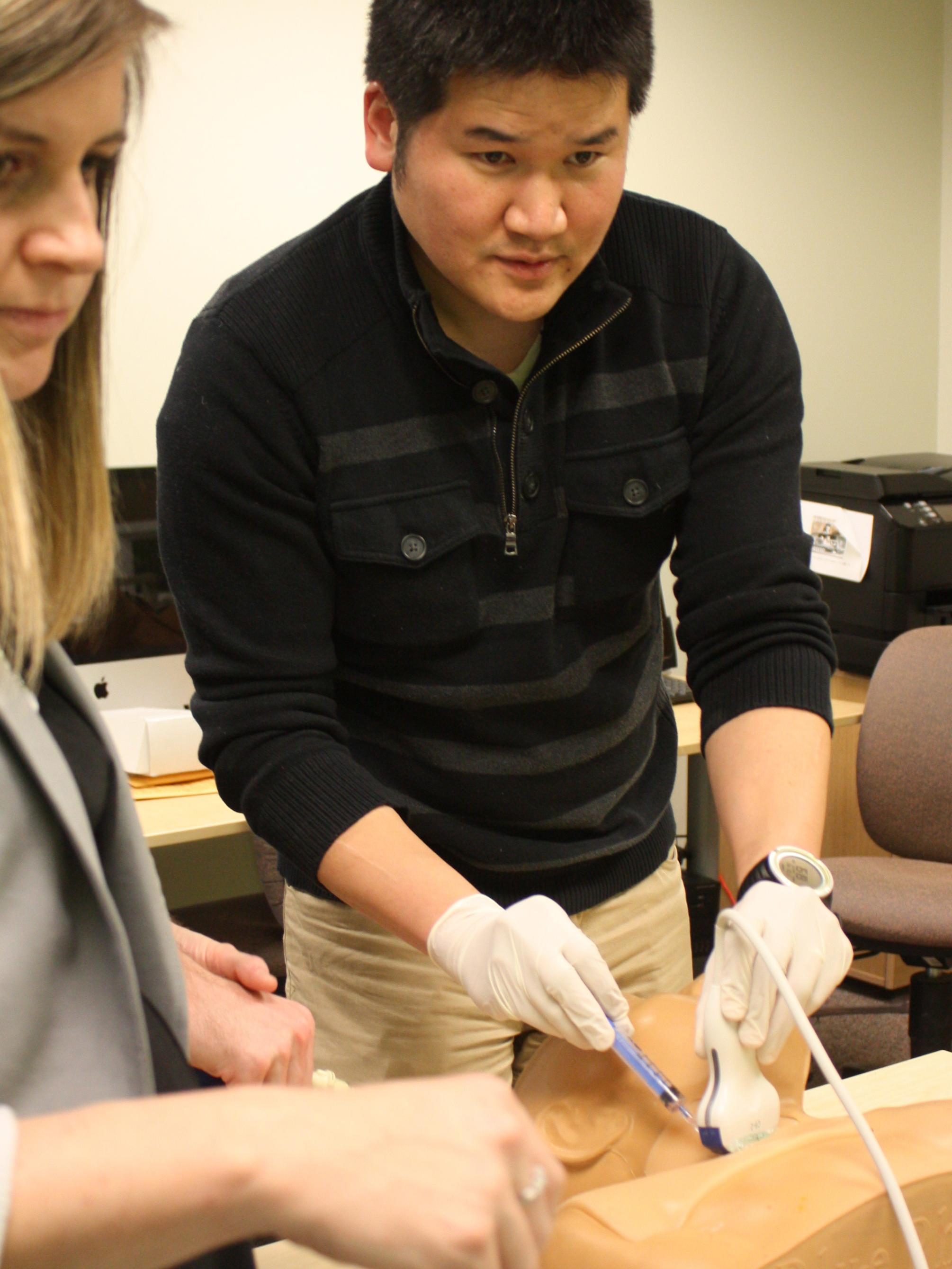Inki Kim, industrial engineering doctoral student, demonstrates the current training method for surgical residents. 