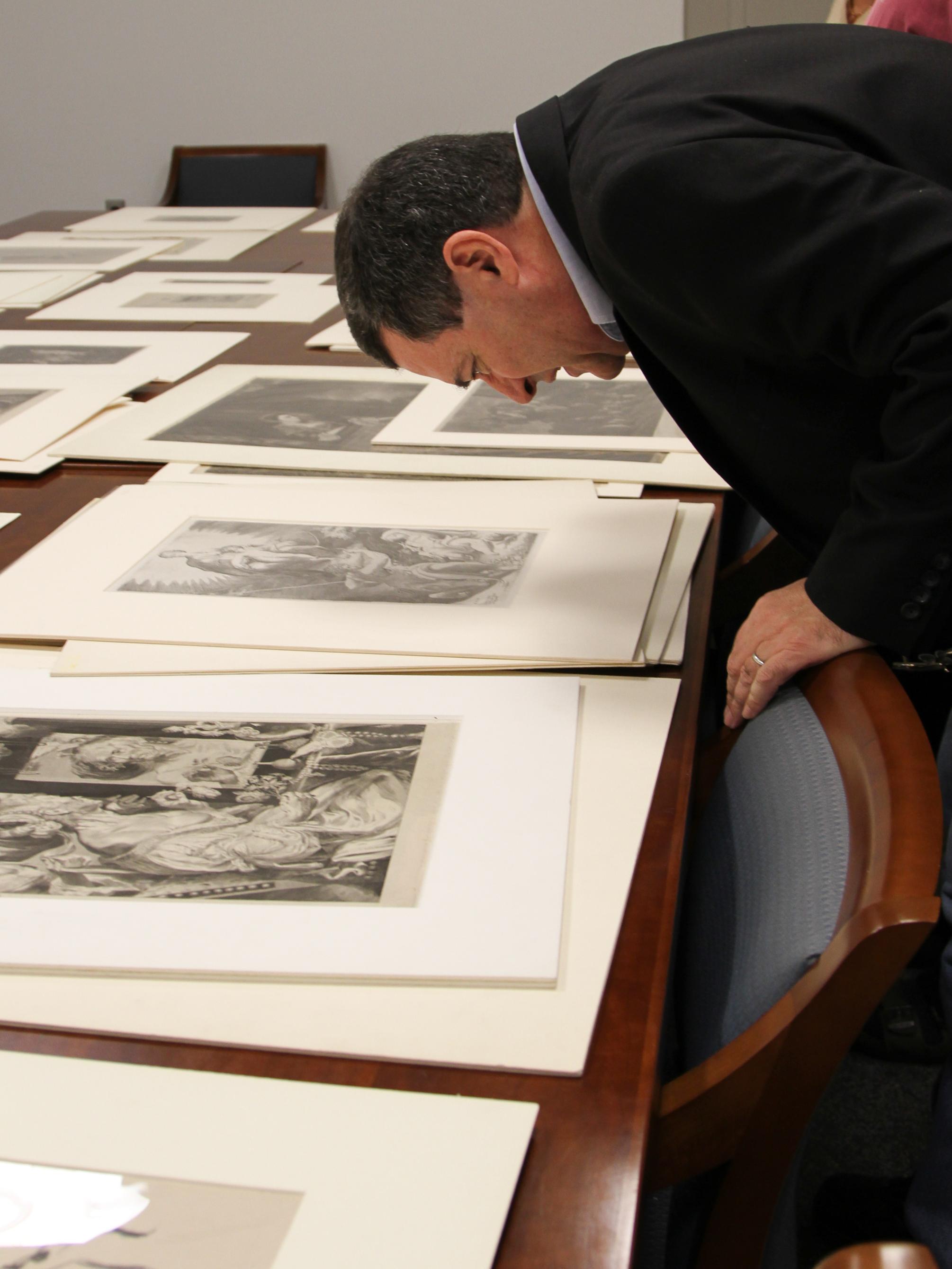 Patrick McGrady looking closely at one of the prints