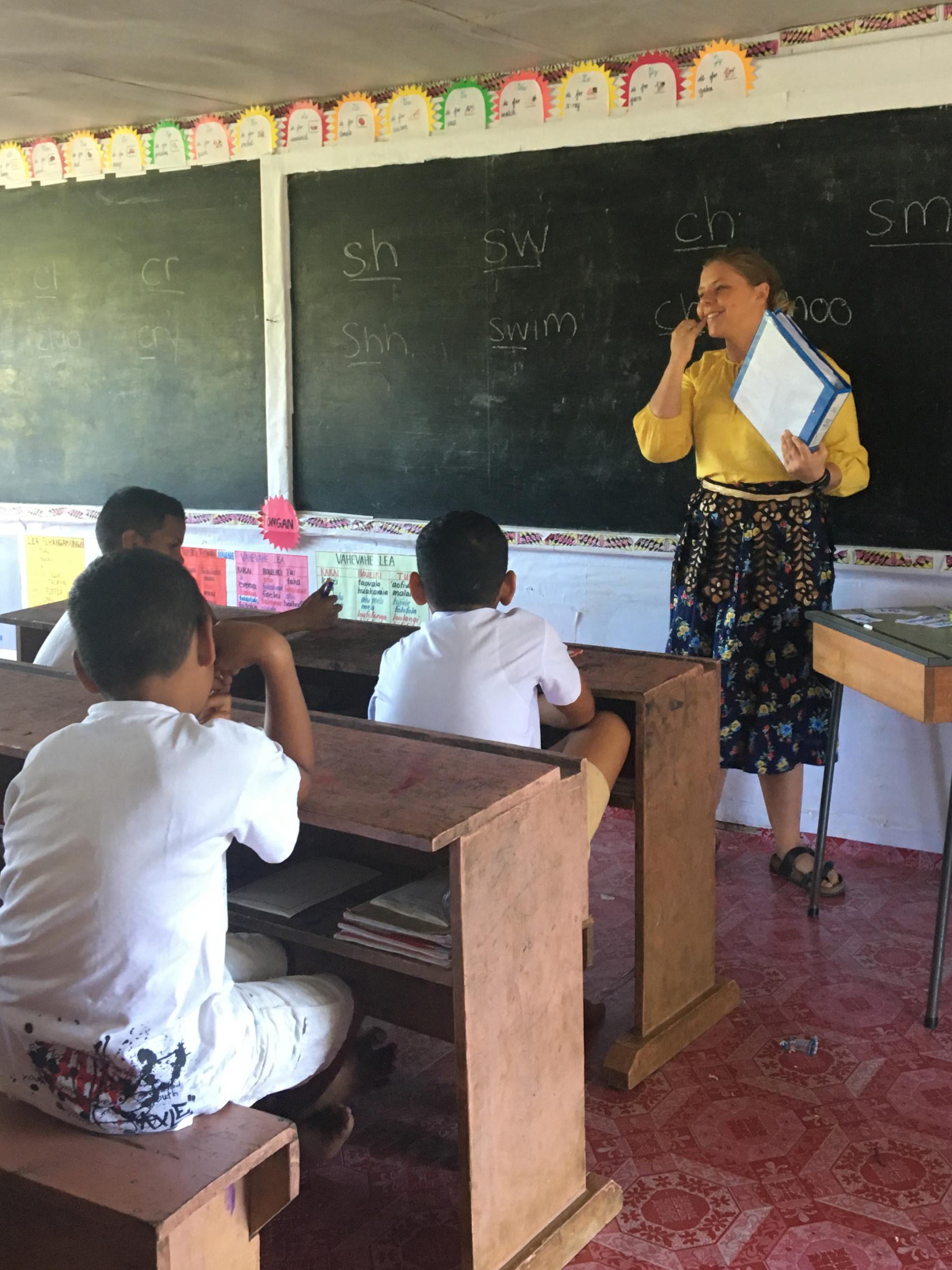 Lynde Metzler standing at front of classroom teaching in Tonga.