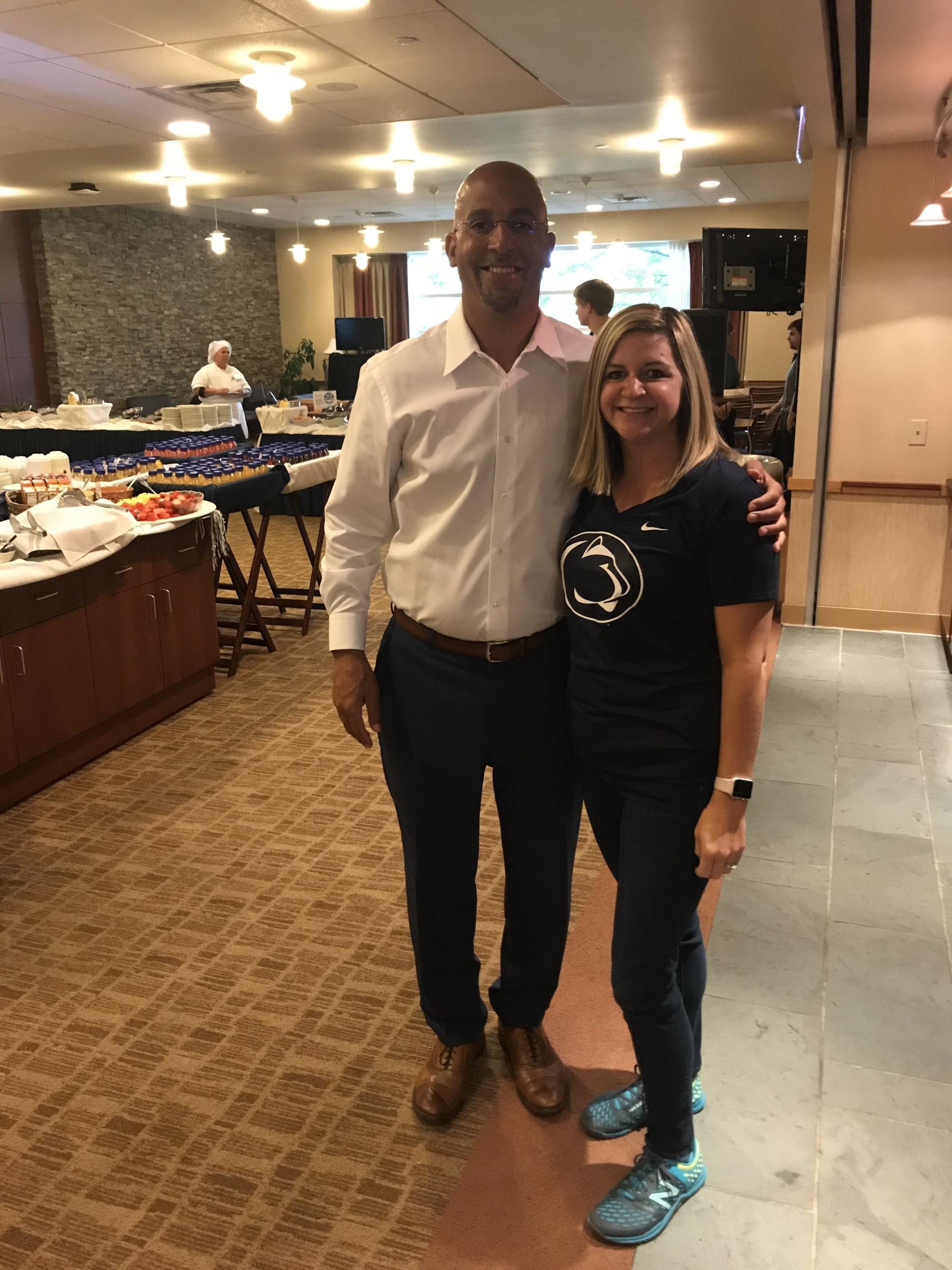 Man and woman pose for photo in front of tables
