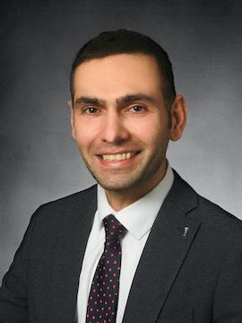 A head and shoulders shot of a man smiling. 