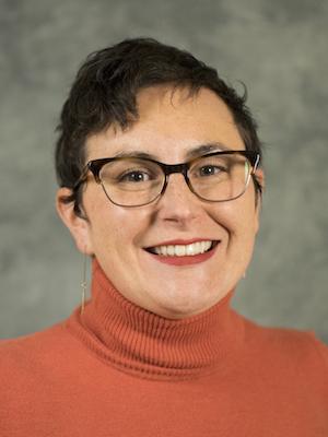 photo portrait of woman wearing black glasses and orange sweater