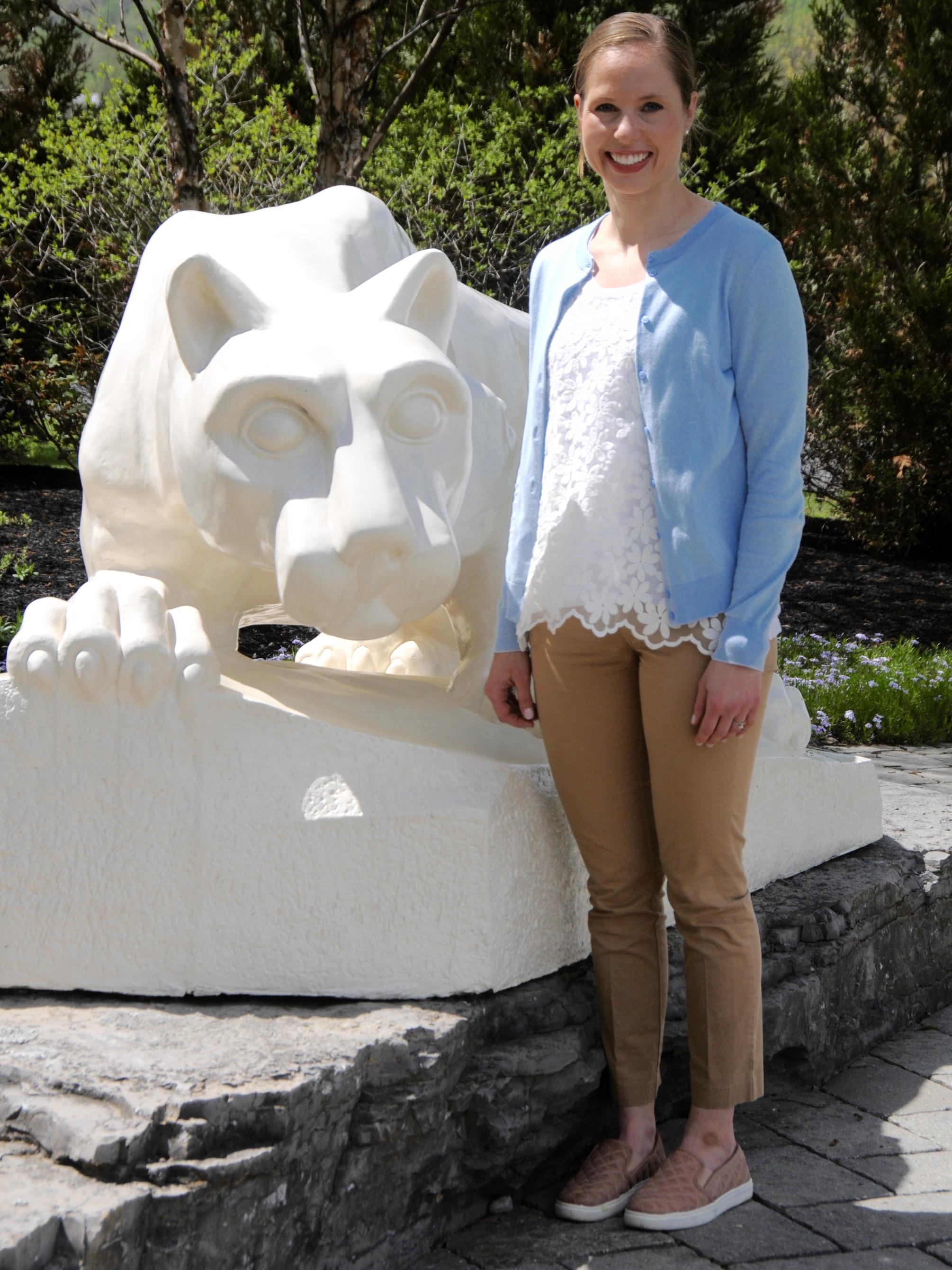 Woman standing in front of lion shrine