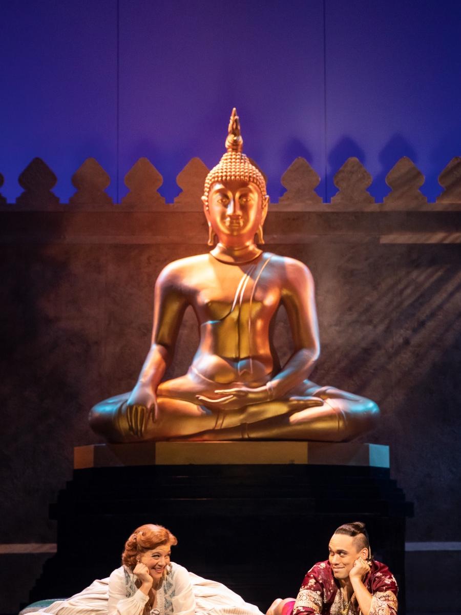 A woman and a man sit on the floor with their heads propped in their hand.