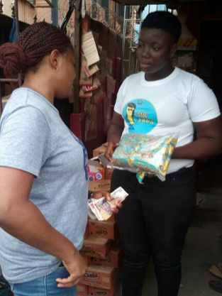 L&L Foods workers pass out peanuts to Nigerians. 