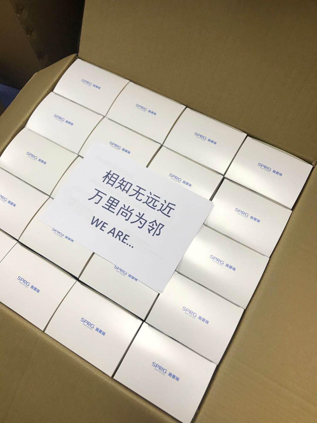 A shipment of masks in boxes with a piece of paper with Chinese writing and "We Are!" written on it