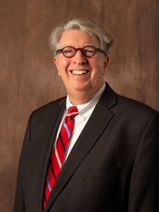 head shot of man with glasses and suit