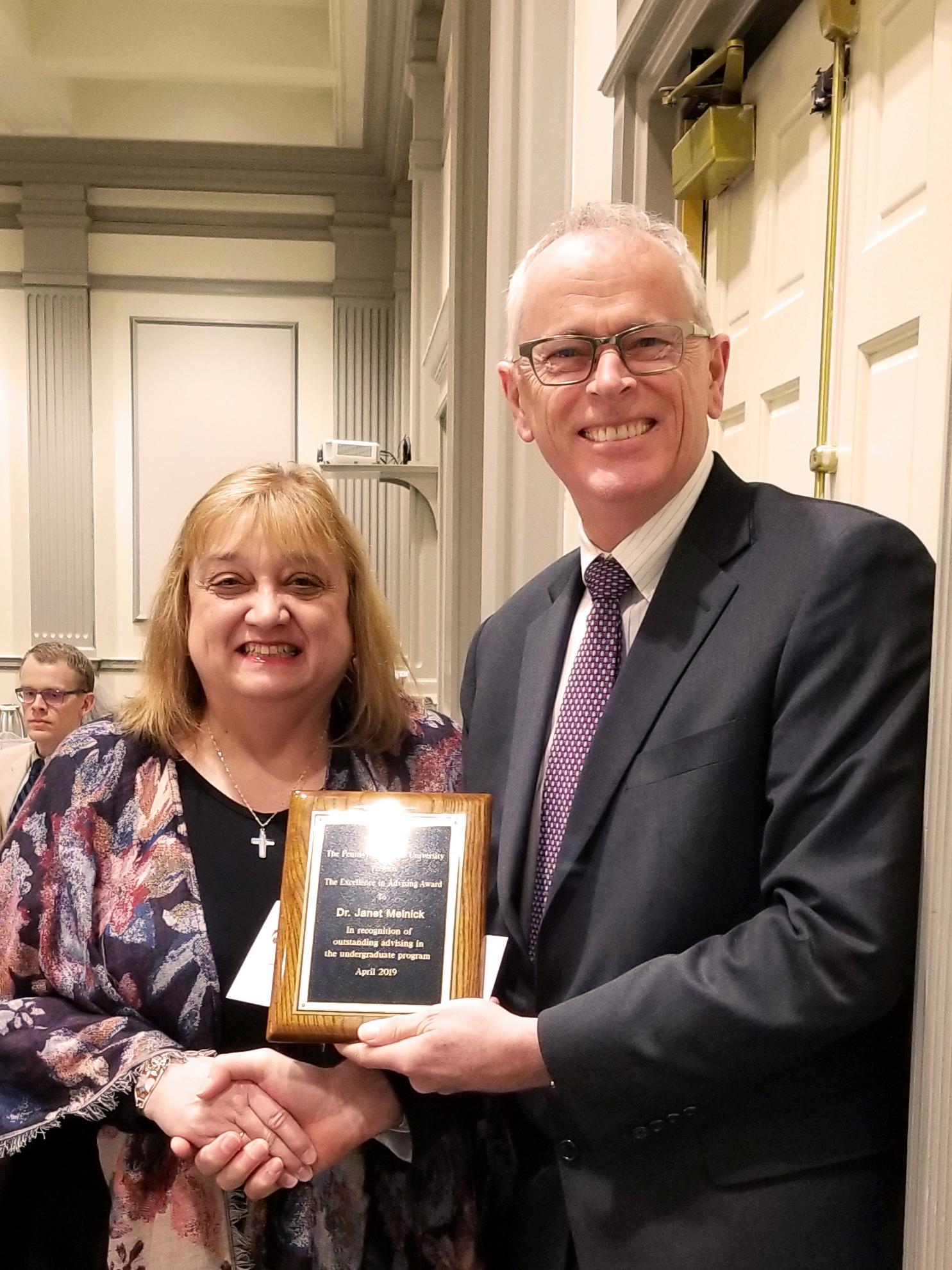 Janet Melnick receiving award from Provost Nick Jones