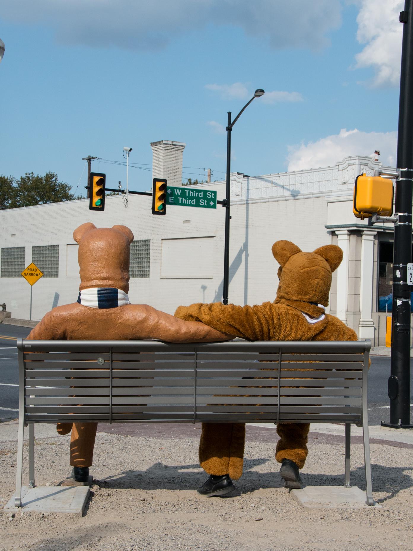 The Nittany Lion mascot checks out the view from the bench featuring a replica mascot.