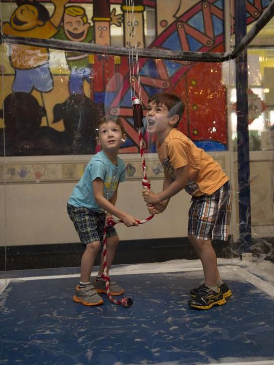 Two boys encase themselves in a bubble at the ExpERIEnce Childrens Museum.