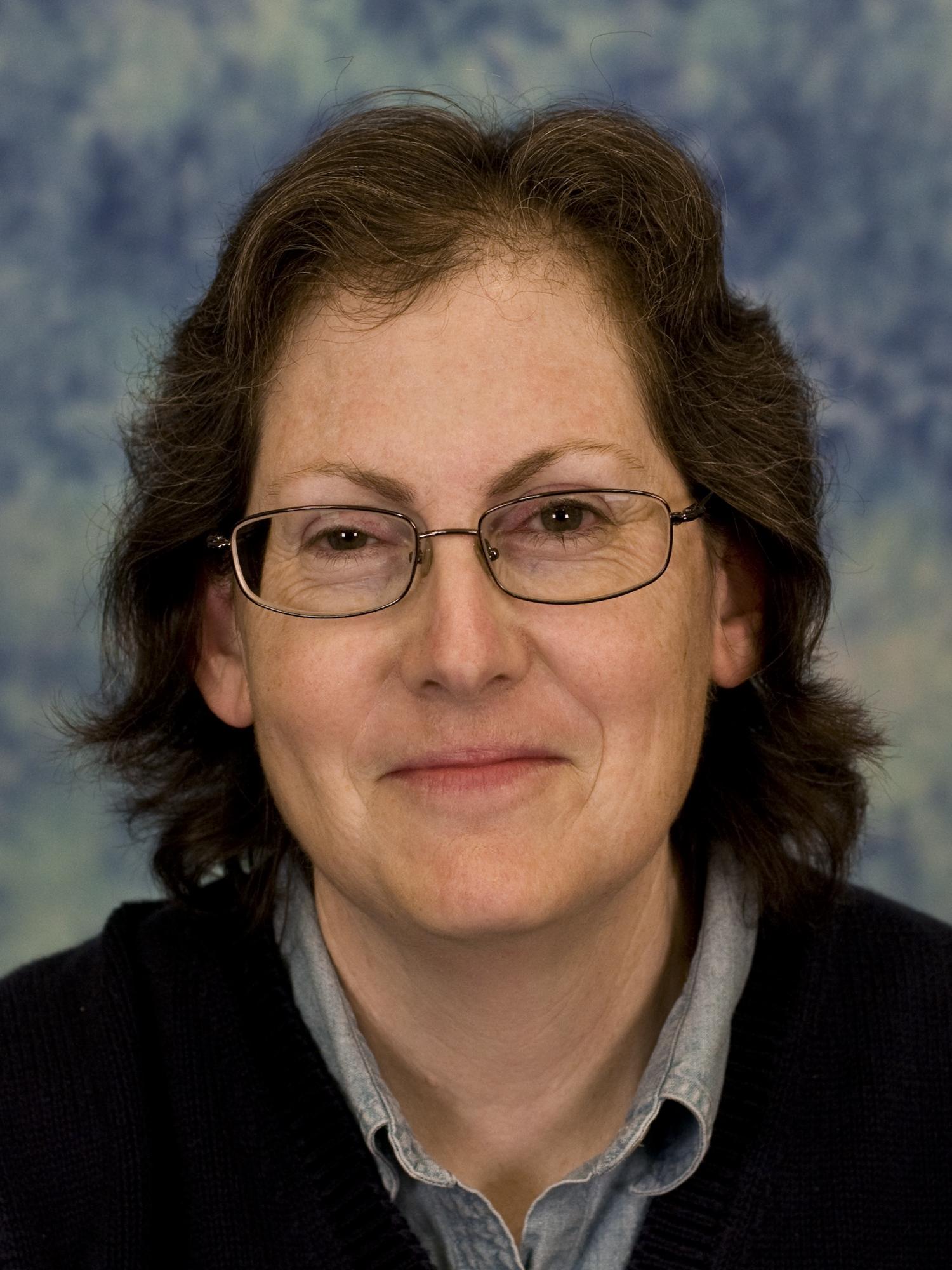 photo portrait of woman wearing glasses, collared shirt and dark sweater