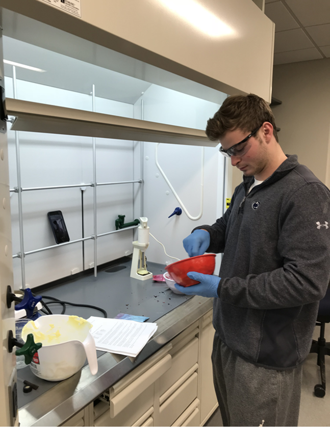 A young man in a lab working with soap