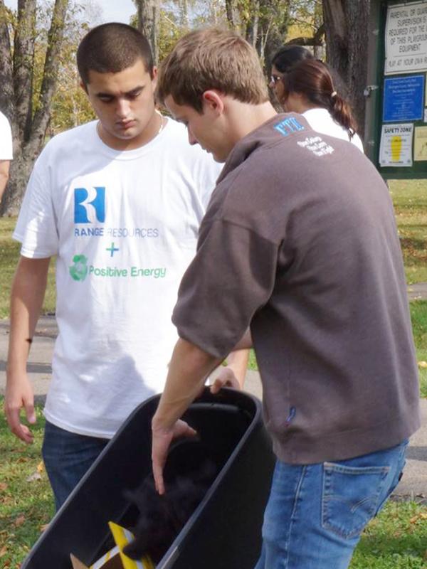 Jacob Morrison and Ryan Will gather supplies such as gloves and trash bags to begin cleanup efforts at Cross Creek County Park.