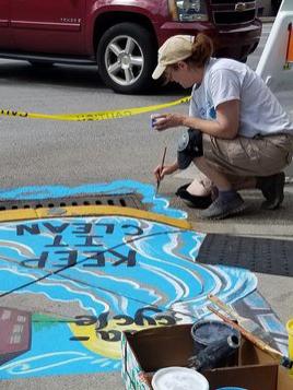 artist paints storm drain