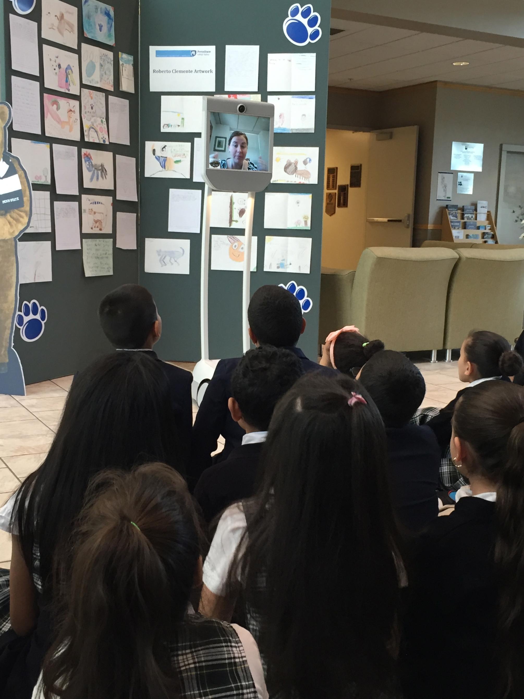principal talks to group of students through Beam robot