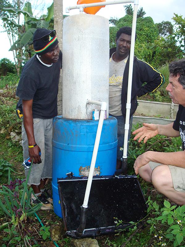 Tim Robinson, who is retiring on June 30, helps residents in Jamaica install a solar water heater. 