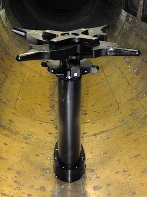 A black pole sits in a metal tunnel. 