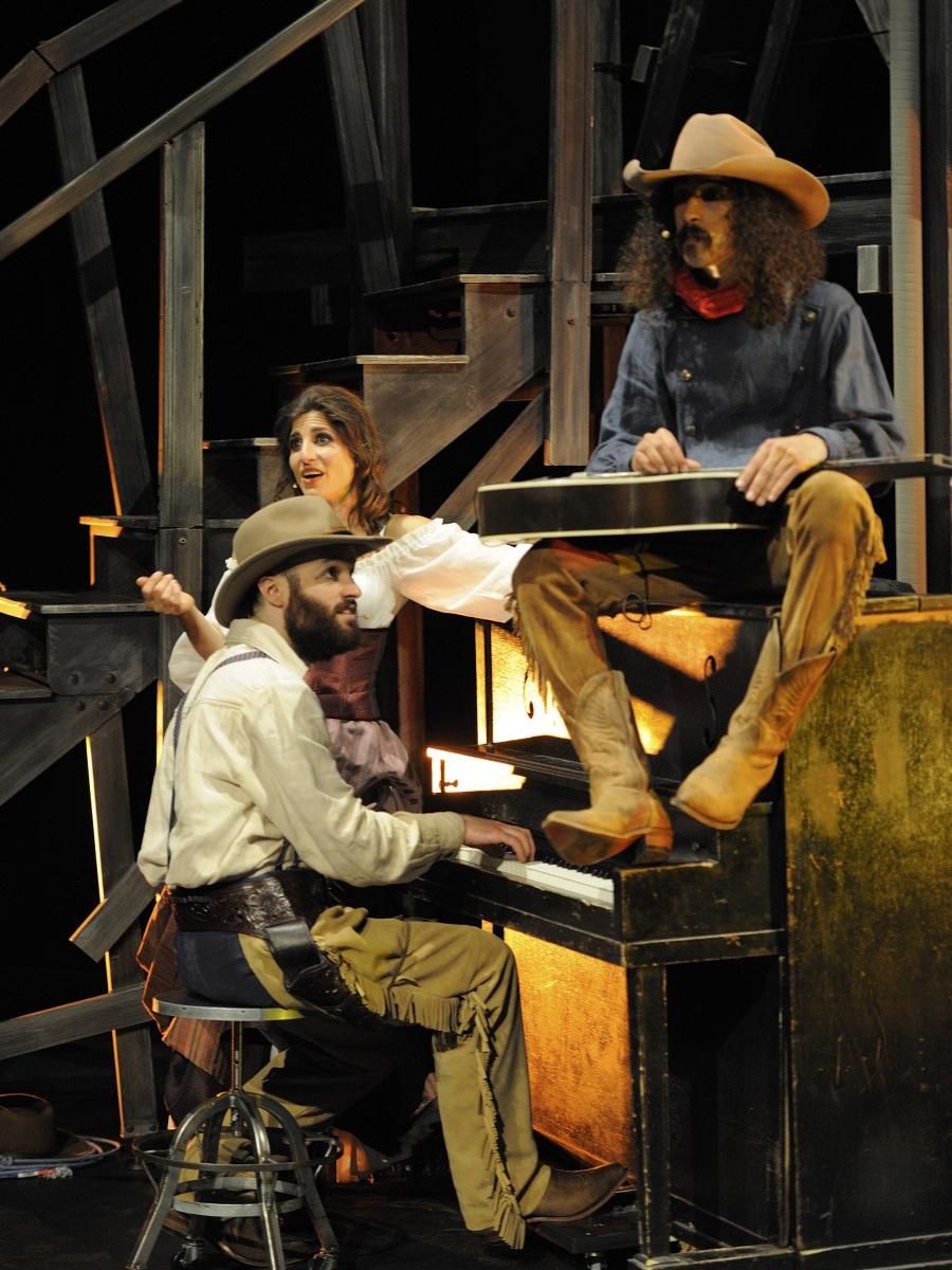 A pianist, a female singer and a lap-guitar player crowd around an upright piano in a scene from Cirque Éloize’s “Saloon.”