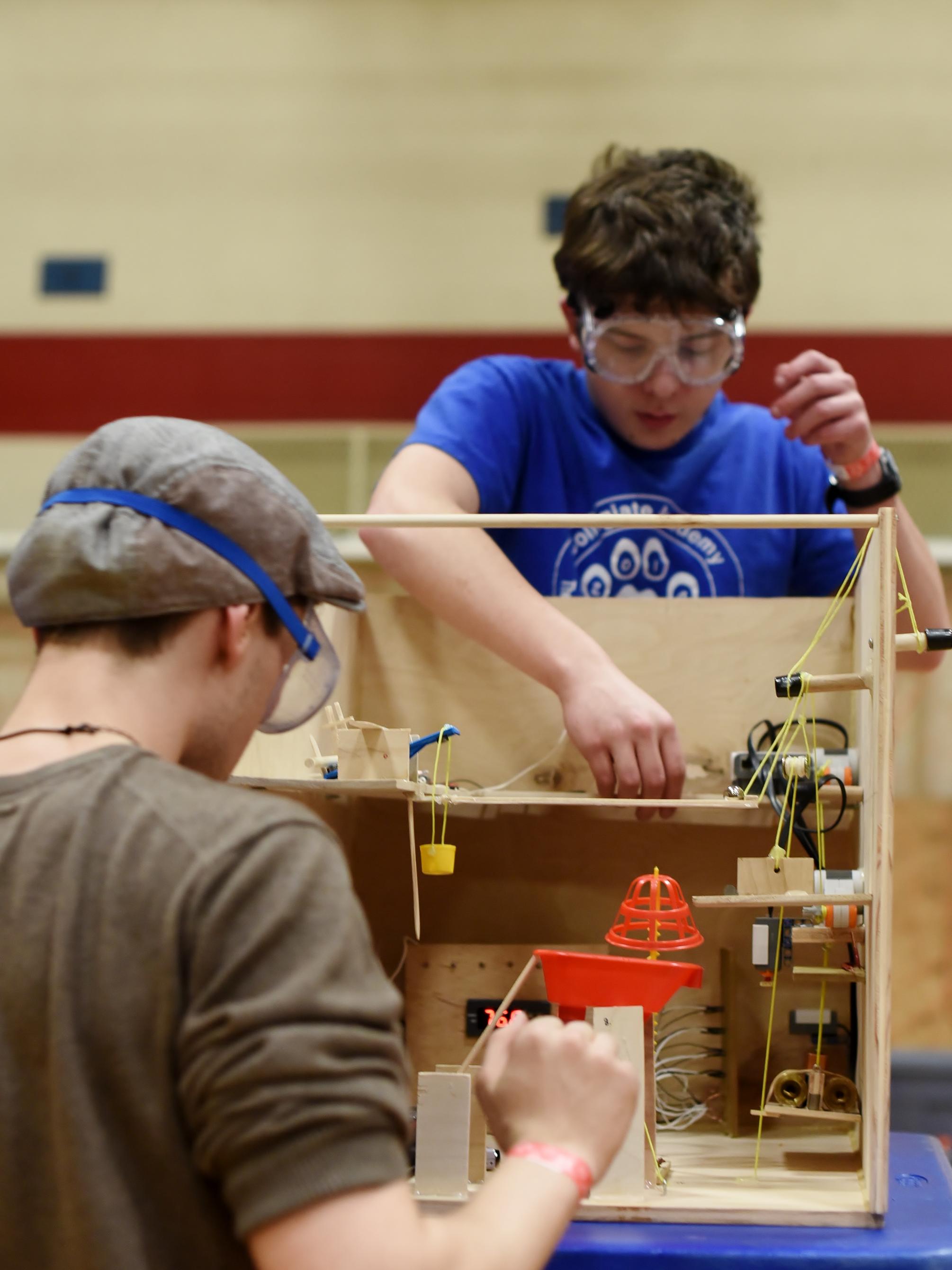 Two high school students test a Rube Goldberg machine during a science event at Penn State Behrend.