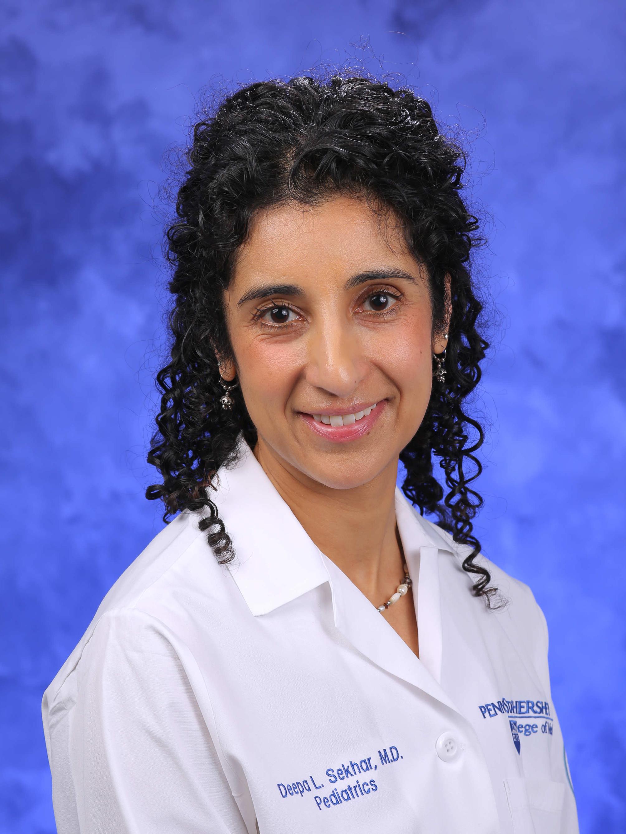A professional photo of Dr. Deepa Sekhar, in a physician's coat.