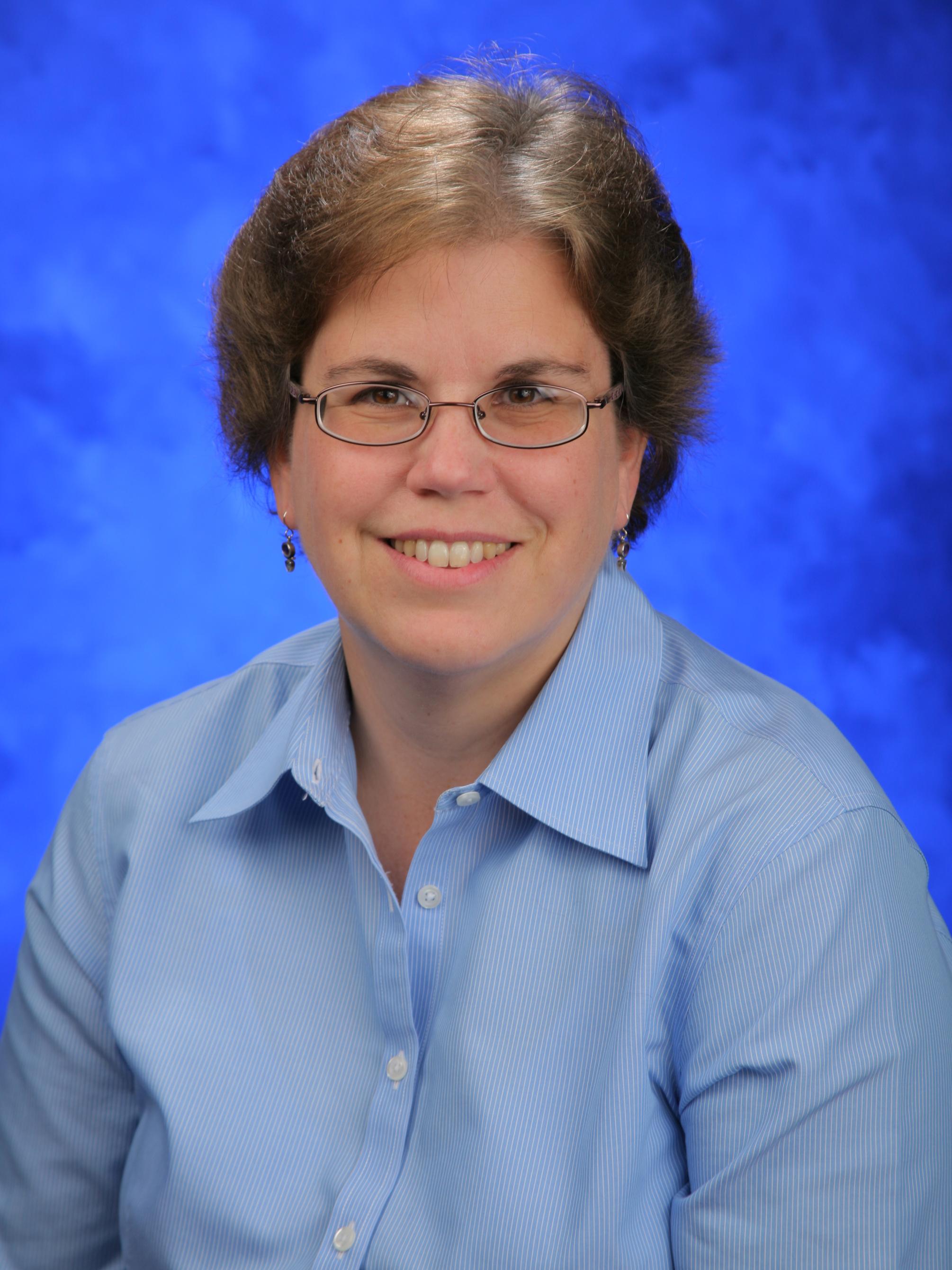 Lisa Shantz looks into the camera wearing a button-up shirt.