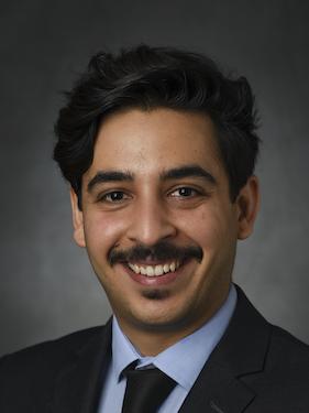 male professor in business attire poses for professional headshot