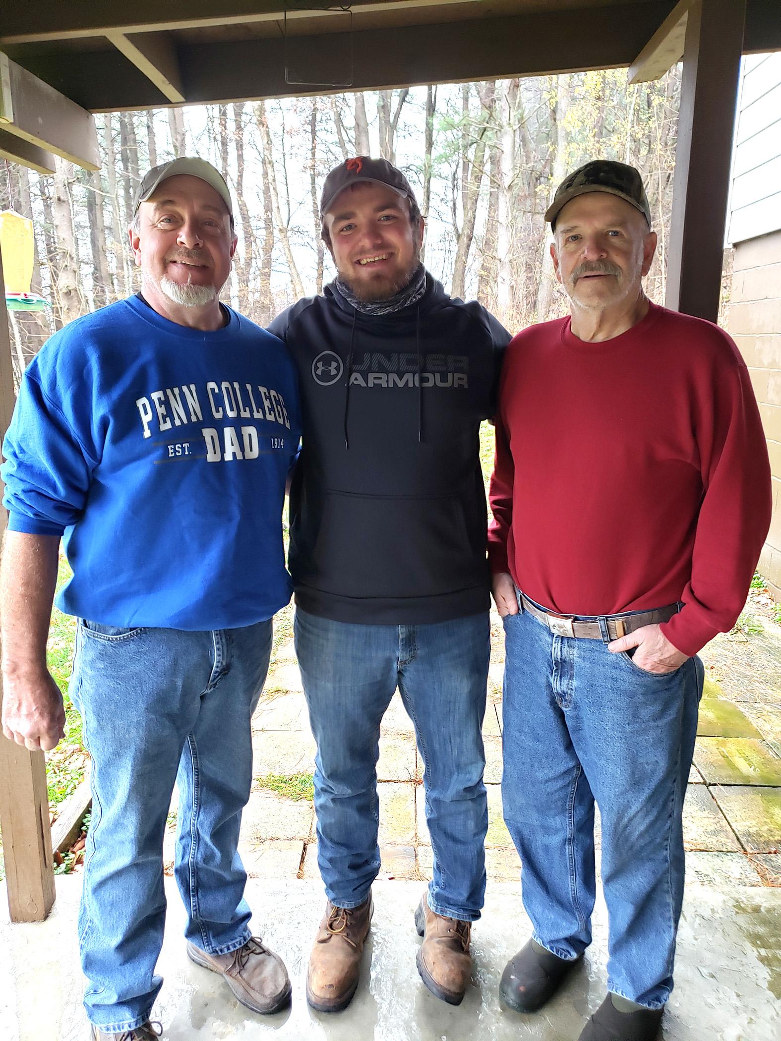 A grandfather, father and adult son standing together