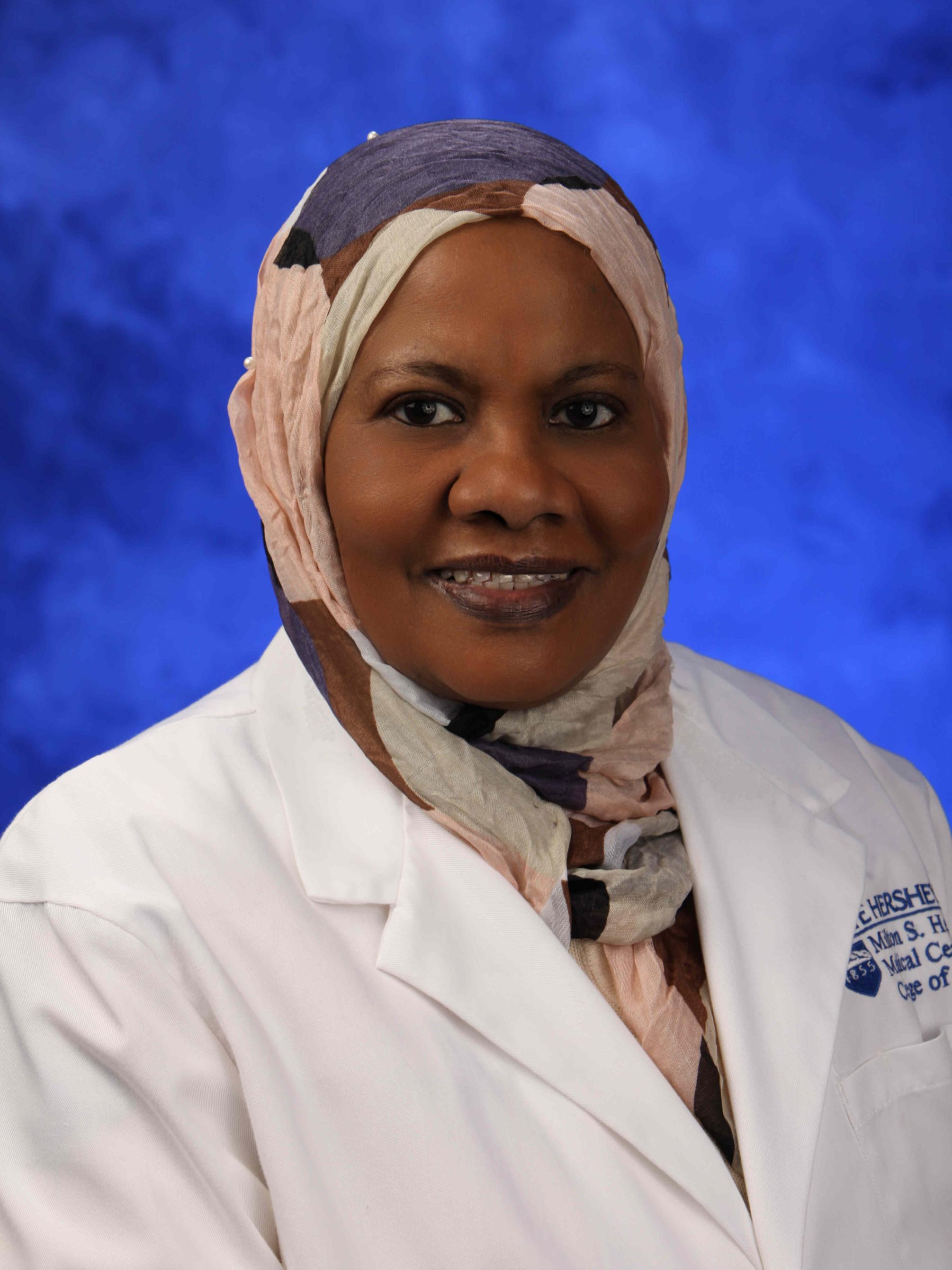 Dr. Alawia Suliman poses for a professional headshot, wearing a physician's coat.