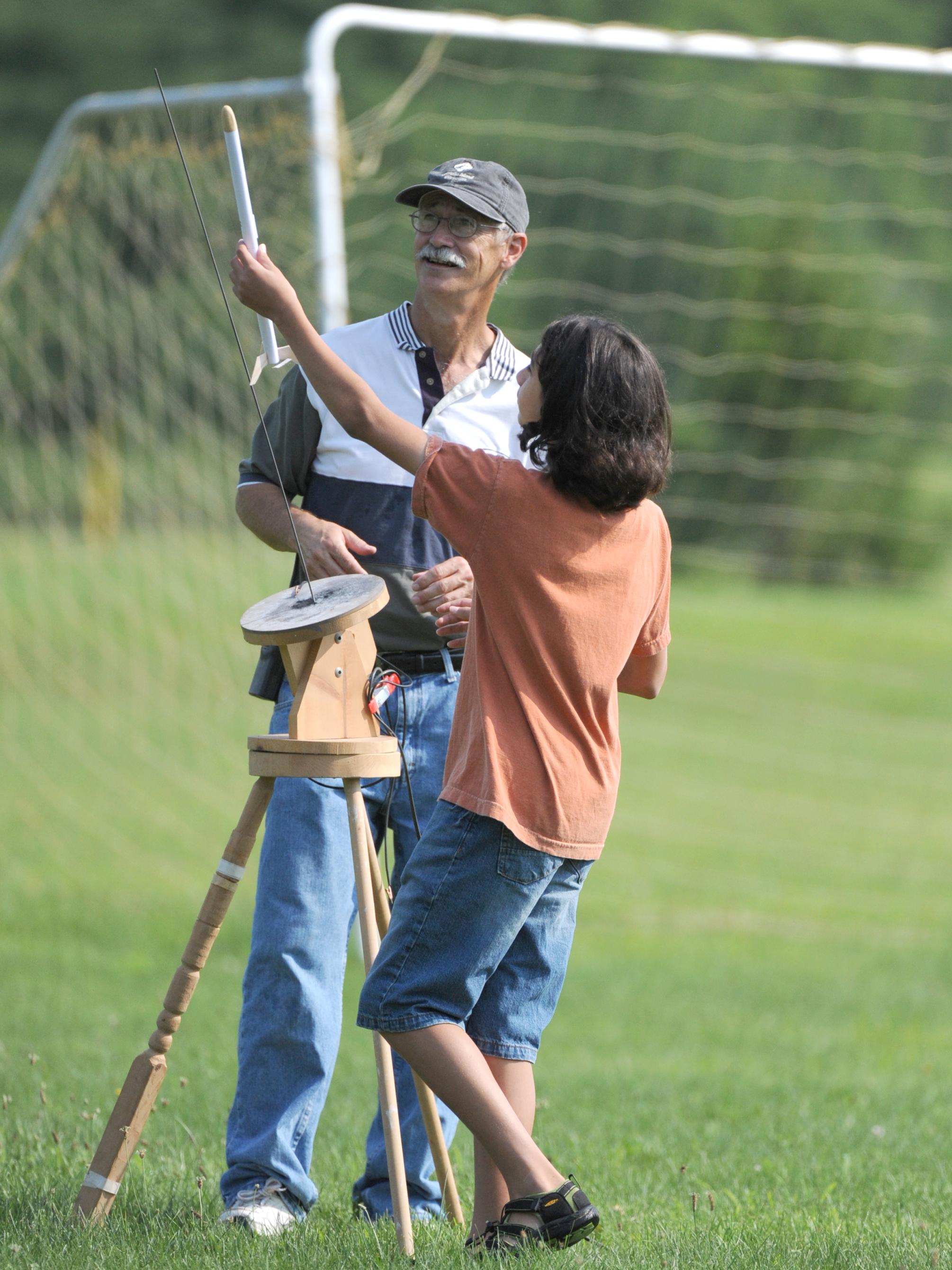 Professor Hal Scholz helps a camper set up his rocket for take-off