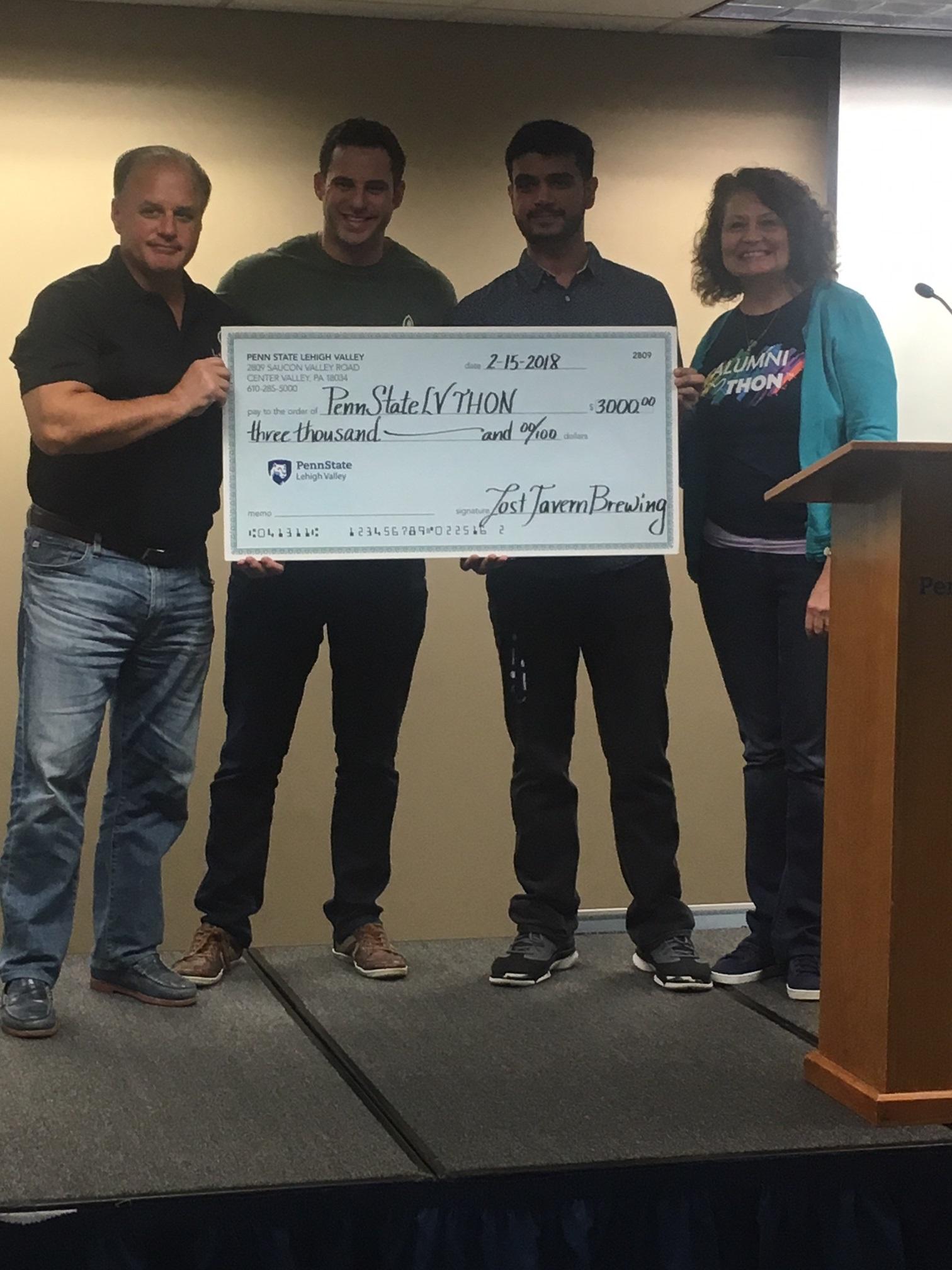 Two men presenting THON check