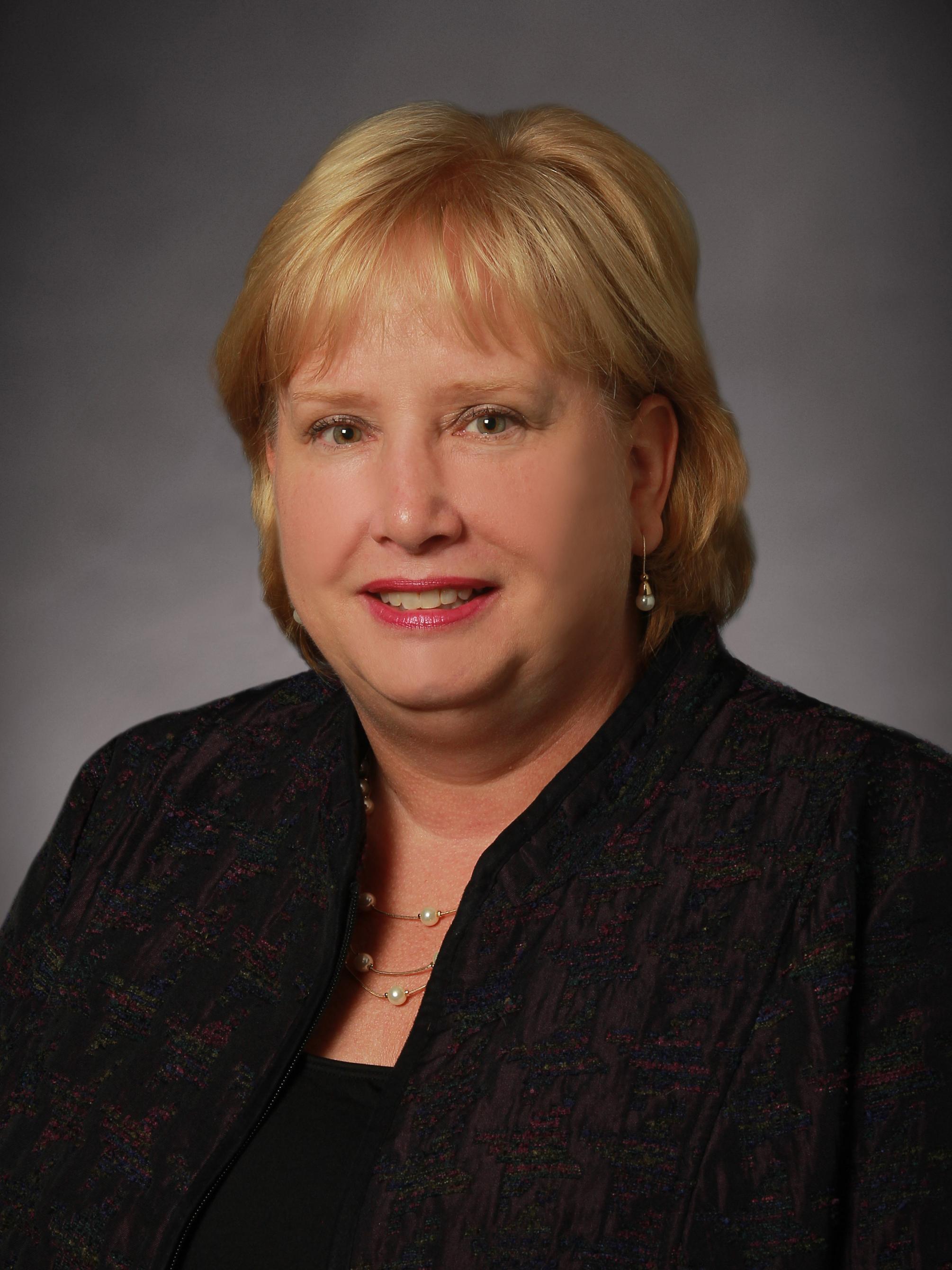 Blonde woman smiling in a posed headshot photo