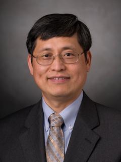 A headshot of a professor wearing glasses. 