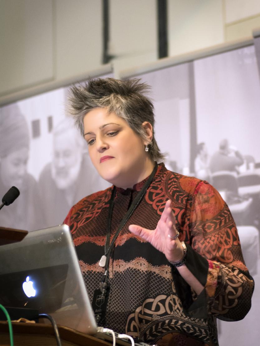 Ann Clements gestures while looking at laptop during Open Innovation Challenge