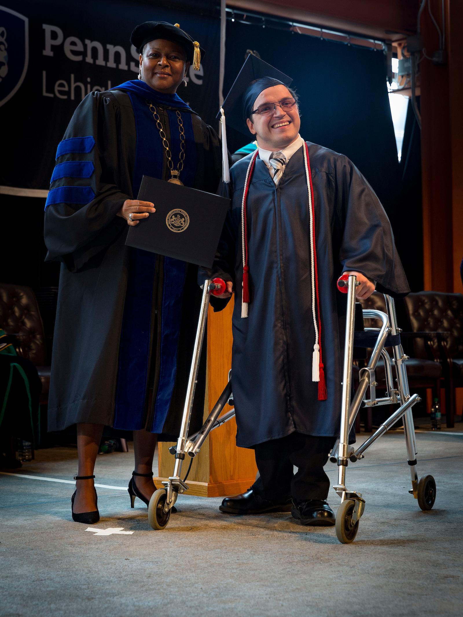 a woman and a man with a walker on stage
